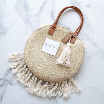 Mavis by Herrera Tulum Fringe Crossbody Bag Against a Marble Background