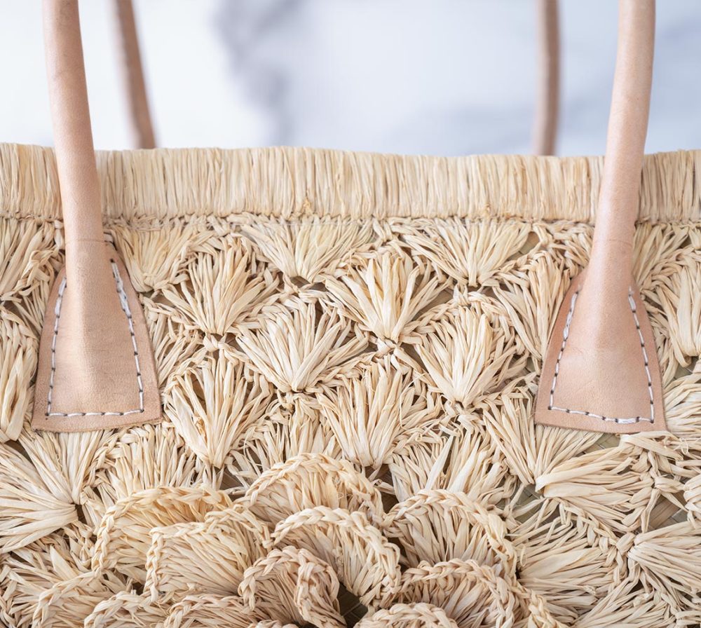 Closeup Top View of the The Big Flower Crochet Basket by Shebobo on a clean white and marble background with palm leaves