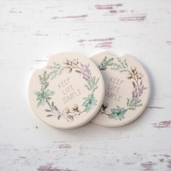 CounterArt & Highland Home Farmhouse Cotton car coaster set with colorful flower art and sitting on top of a white rustic wood background