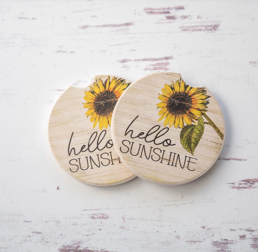 CounterArt & Highland Home Hello Sunshine car coaster set with colorful flower art and sitting on top of a white rustic wood background