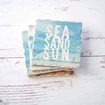 CounterArt & Highland Home Beachscapes coaster set stacked on one another on a white rustic wood background