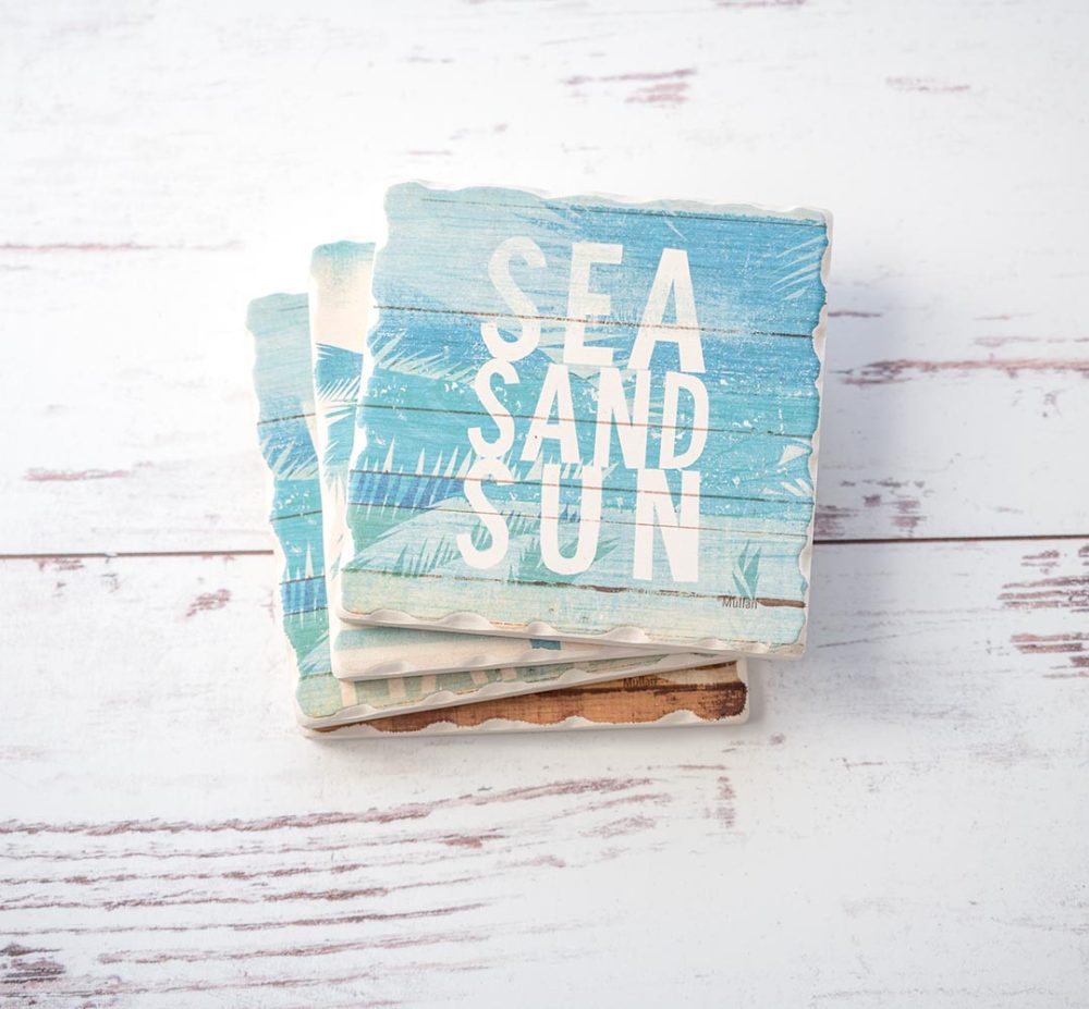 CounterArt & Highland Home Beachscapes coaster set stacked on one another on a white rustic wood background
