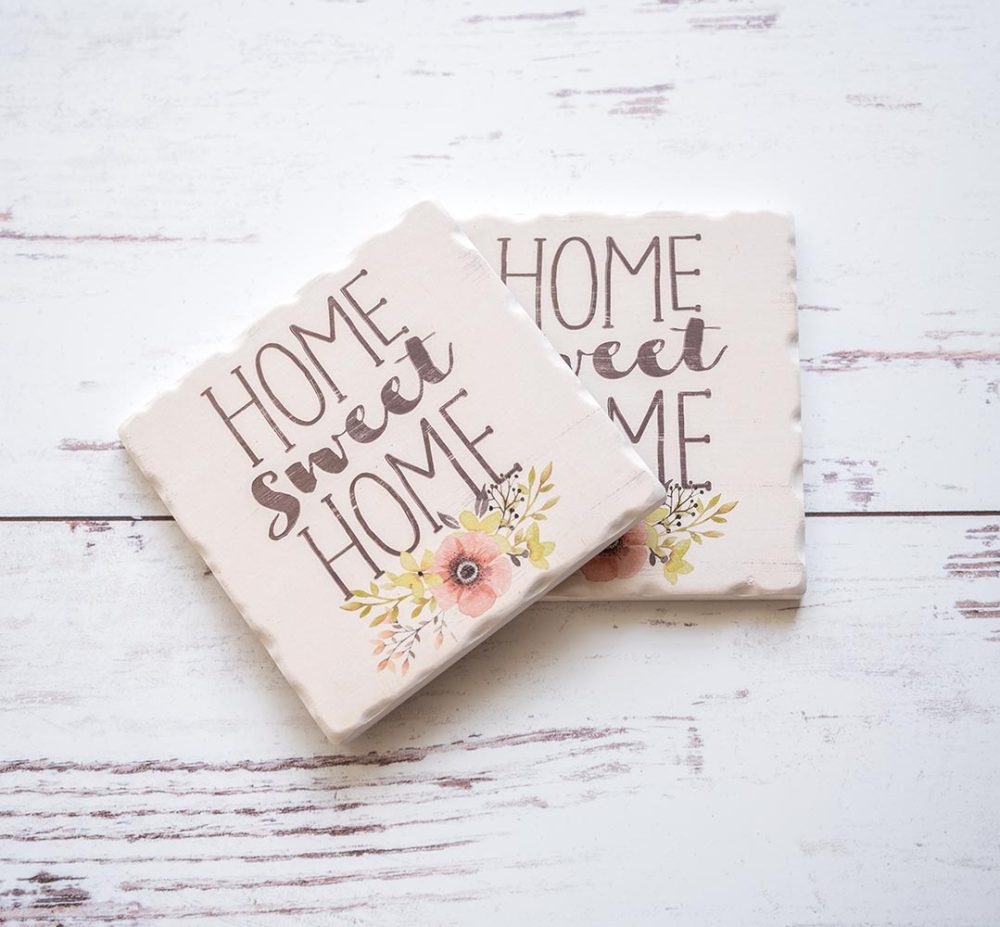 Pair of Home Sweet Home Coasters sitting on top of a white rustic wood background