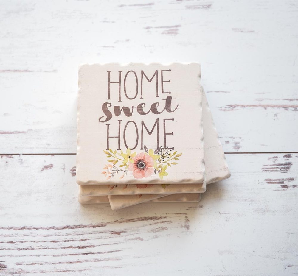 Set of of Home Sweet Home Coasters sitting stacked on top of each other on a white rustic wood background