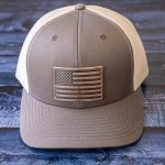 Front View of the RANGE LEather American Flag hat in Brown & Khaki on a rustic dark wood background