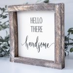 Angled View of the Joshua Jar Hello There Handsome wood sign against a white backdrop and greenery
