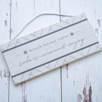 Top View of the Beach House Rules Wooden Accent Sign by Gia Roma Against a Rustic Wooden Backdrop