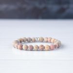 Back View of the Steel & Barnett Stones Beads Bracelet in Matt Rainbow on clean white wood with dark wood background