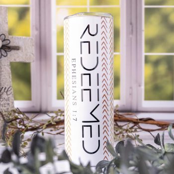 Redeemed Ephesians Skinny Tumbler by Emma K Designs in Front of a Kitchen Window Background with Greenery in Front and Behind the TUmbler