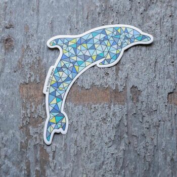 4" Die-Cut Dolphin Sticker by the Happy Sea Against a Rustic Wood Background