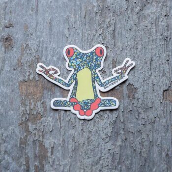3" Die-Cut Yoga Frog Sticker by the Happy Sea Against a Rustic Wood Background