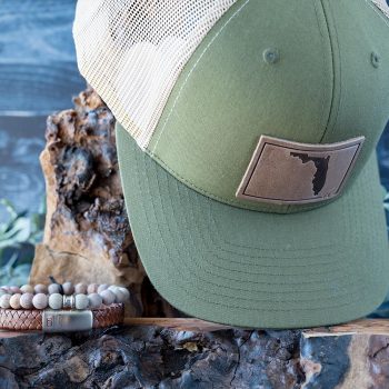 Men's Sunsational Set of the State of Florida RANGE LEather Hat in Moss & Khaki with the Steel & Barnett Matt Rainbow Beads Bracelet and Caramel Cornall Leather Bracelet on wood and a Rustic Background with Greenery