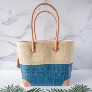 Back View of the Trinidad Two Tone Tote Bag in Aqua by Shebobo Against a Marble and Clean White Background with Palm Leaves