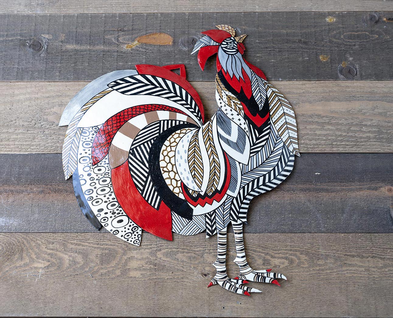 Top View of the Colorful Rooster Steel Drum Wall Art Piece by Papillon Marketplace on a Wood Background