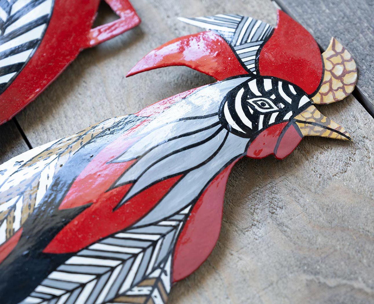 Closeup Top Detailed View of the Colorful Rooster Steel Drum Wall Art Piece by Papillon Marketplace on a Wood Background