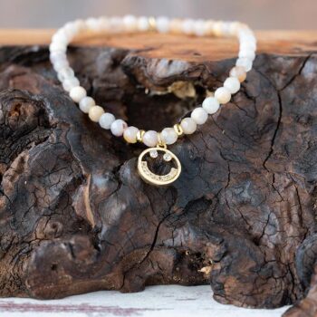 Lenny & Eva Wanderlust Smiley Bracelet resting on a piece of wood with a rustic background