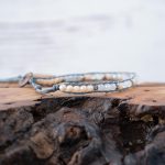 Right View of the Lotus & Luna Song of Selene Moonstone bracelet laying on a piece of wood with white rustic wood background