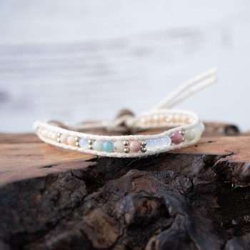 Lotus & Luna Watermelon Wishes Moonstone bracelet laying on a piece of wood with white rustic wood background