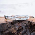 Right View of the Lotus & Luna When the Stars Align Moonstone bracelet laying on a piece of wood with white rustic wood background