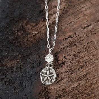Top View of the Starfish Necklace with Swarovski Crystals by VB&CO Designs on Dark Wood