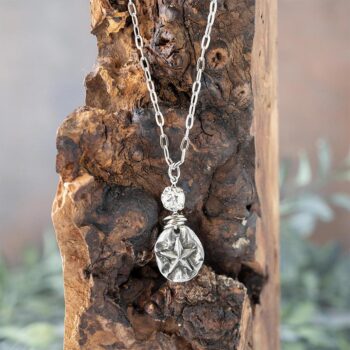 Starfish Necklace with Swarovski Crystals by VB&CO Designs Hanging on a Piece of Wood