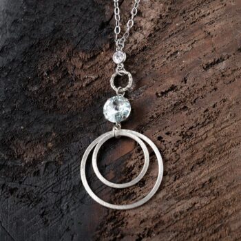 Top View of the Light Azure Swarovski Hoop Necklace on Dark Wood Background