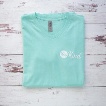 Flat Lay of the Women's Be Kind V-Neck Tee in Mint by Costa Threads on a White Rustic Background
