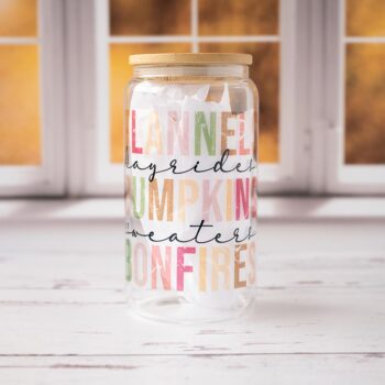 Front View of the Fall Things Glass Tumbler Against a Fall Scene Window and on top of Rustic Wood