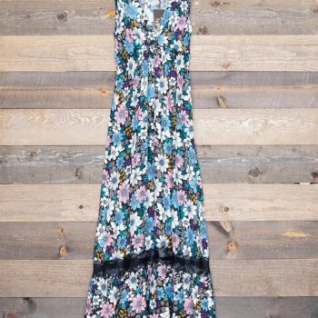 Front view of the Penelope Long Dress by Secret Language hanging against a rustic wood backdrop