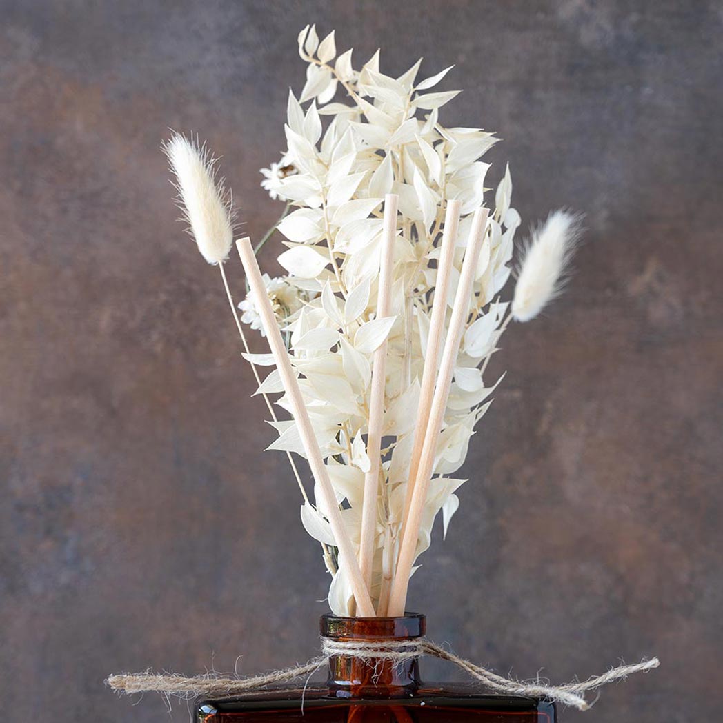 Closeup back view view of the White Tea & Pampas Bouquet Reed Diffuser on a rustic and white wood background