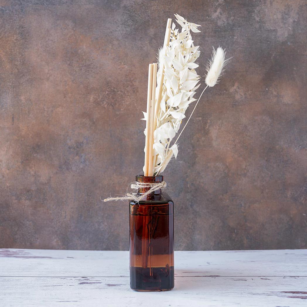 Right side view of the White Tea & Pampas Bouquet Reed Diffuser on a rustic and white wood background