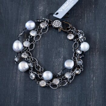 Top view of the Oyster Cove pearl bracelet on a rustic dark piece of driftwood