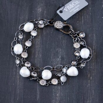 Top view of the Sandy Shores womens' peacock pearl bracelet clasp on a dark piece of rustic wood