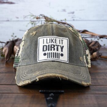 I Like it Dirty distressed trucker cap perfect for the southern lifestyle against a rustic background