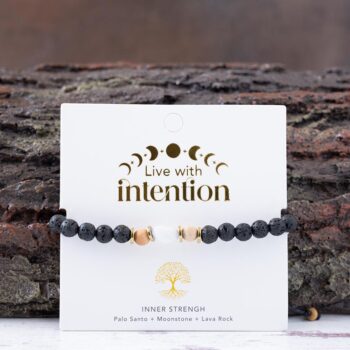 Mystic Flame Palo Santo Moonstone Bracelet with Lotus & Luna branded card against a rustic piece of wood