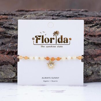 The Always Sunny in Florida charm bracelet against a textured piece of wood