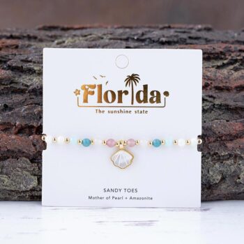 The Florida Sandy Toes charm bracelet against a textured piece of wood