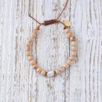 Top View of the Lunar Wisdom Palo Santo Moonstone Bracelet on a rustic piece of wood
