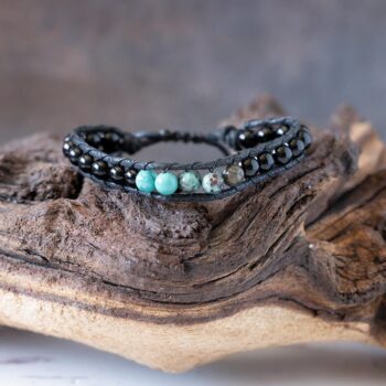Men's Ocean Protector beaded bracelet front view resting on a rustic piece of wood