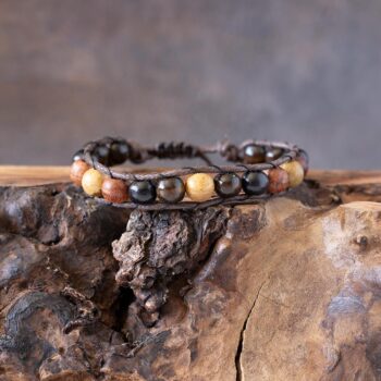 Men's Vintage Village beaded bracelet front view resting on a rustic piece of wood
