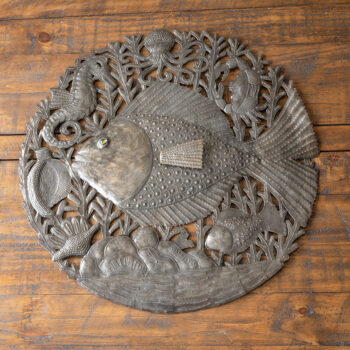 Top view of the Mom and Baby Fish wall decor piece against a dark rustic piece of wood