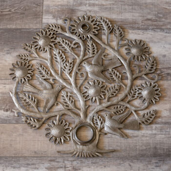 Top view of the Sunflower and Birds Tree of Life wall decor piece against a dark rustic piece of wood