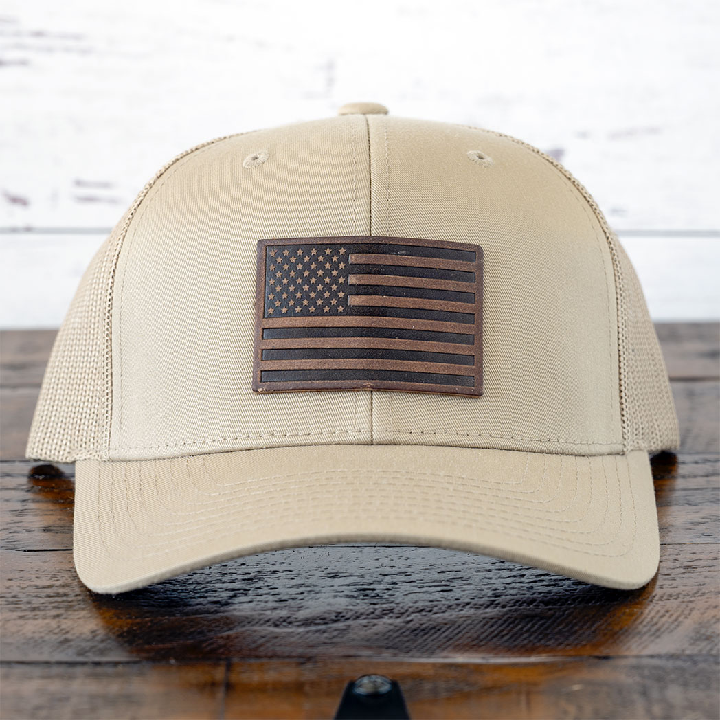 RANGE Leather American flag leather patch hat in tan against a rustic wood background