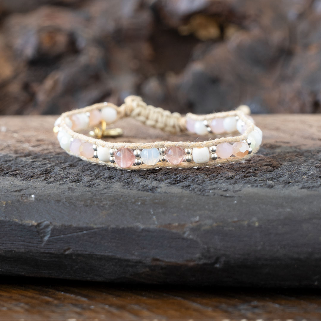 Coastal Coral Healing Stones Bracelet by Lotus & Luna on a rustic piece of wood and against rustic wood backdrop