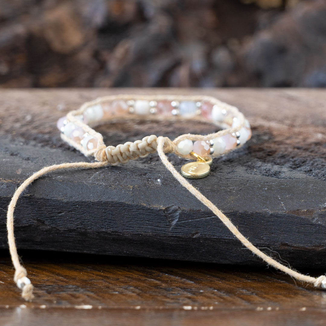 Back view of the Coastal Coral Healing Stones Bracelet by Lotus & Luna on a rustic piece of wood and against rustic wood backdrop