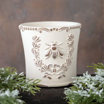 Brown's Creek Honey Farm Fraser Fir Bee Planter Vessel Candle on a dark piece of wood with rustic backdrop with greenery