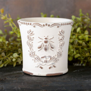 Brown's Creek Honey Farm Dry Gin & Cypress Bee Planter Vessel Candle on a dark piece of wood with rustic backdrop with greenery