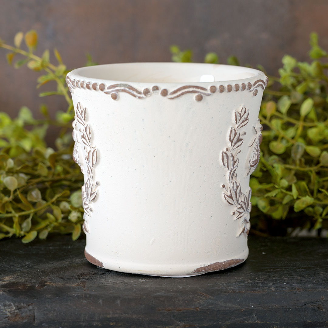 Side view of the Brown's Creek Honey Farm Dry Gin & Cypress Bee Planter Vessel Candle on a dark piece of wood with rustic backdrop with greenery