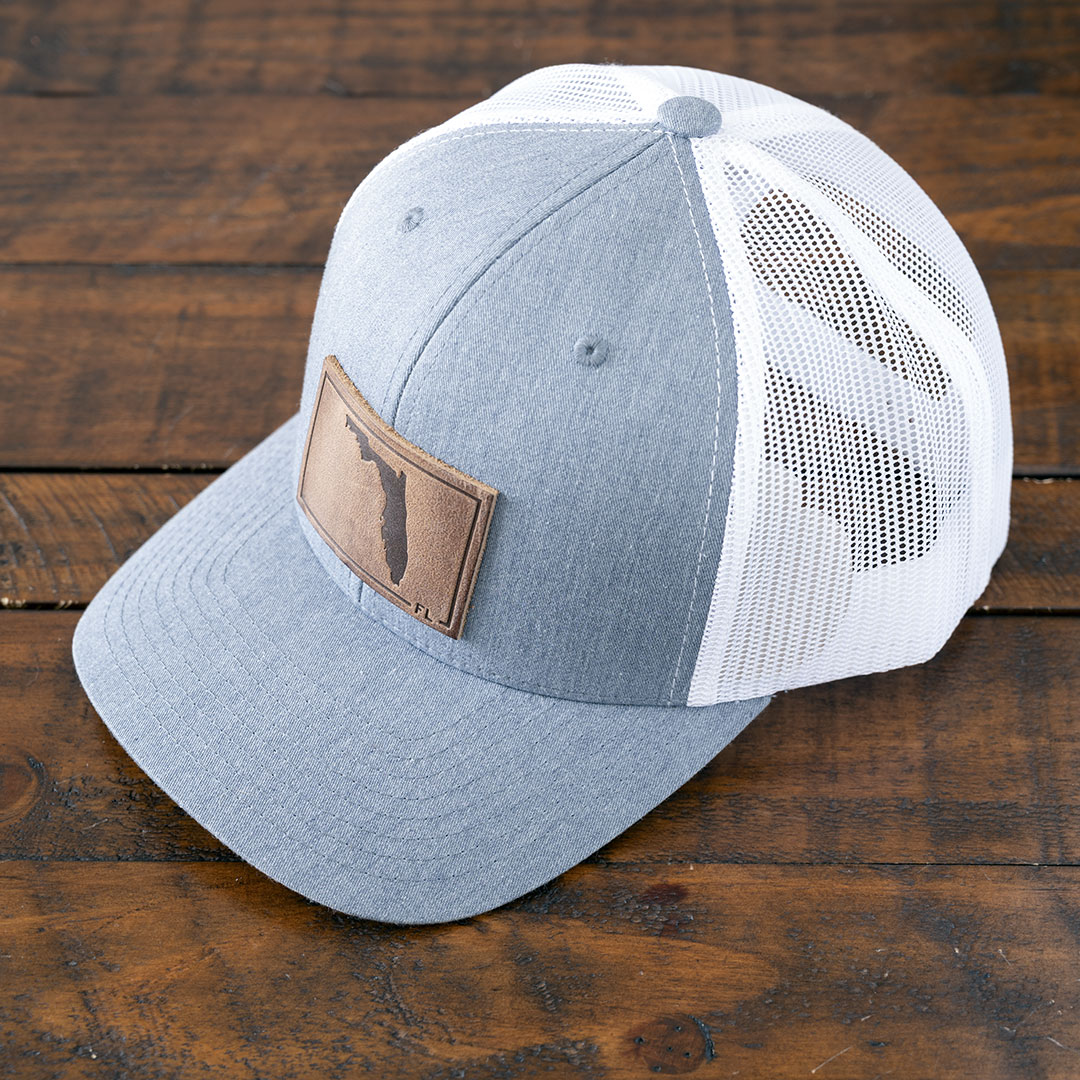 State of Florida leather patch hat in the color heather gray & white by RANGE Leather on a rustic wood tabletop