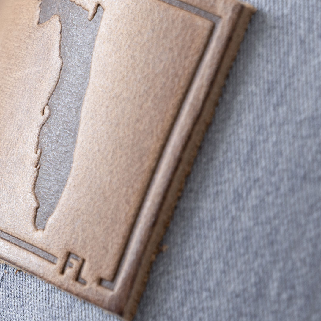 Closeup of the leather patch on the State of Florida leather patch hat in the color heather gray & white by RANGE Leathe